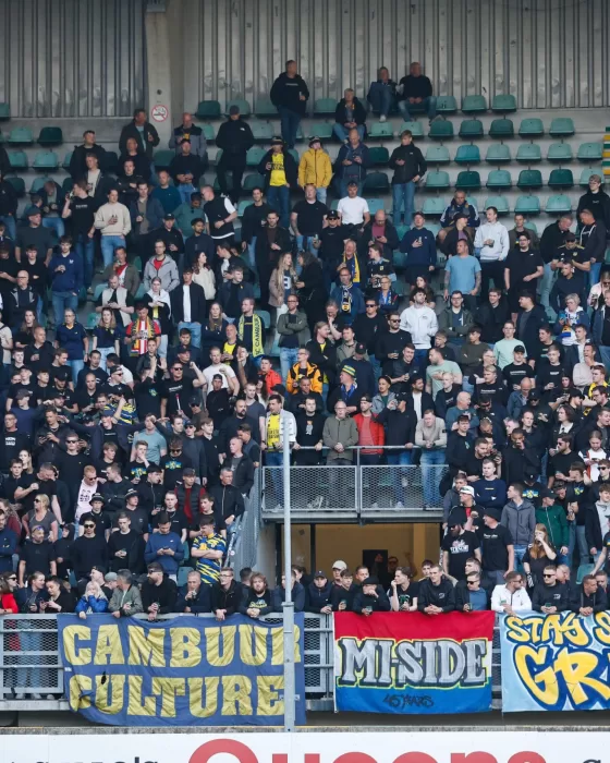 Volle uittribune met spandoeken