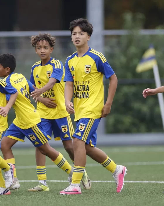 Jonge jeugdspelers vieren een doelpunt
