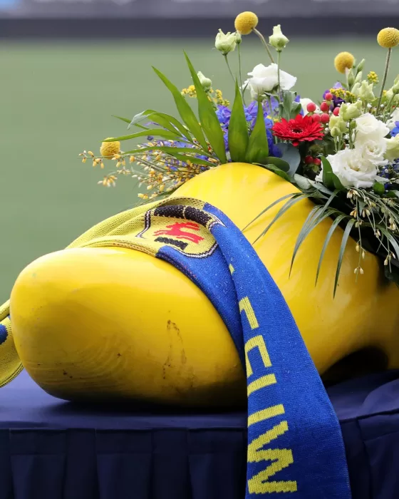 Gele klomp met bloemen en foto als eerbetoon