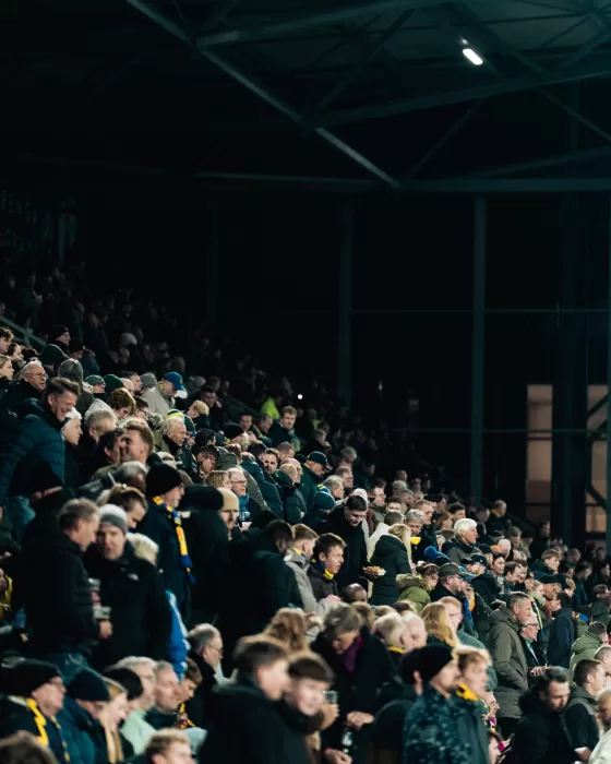 Supporters op de tribune in tegenlicht