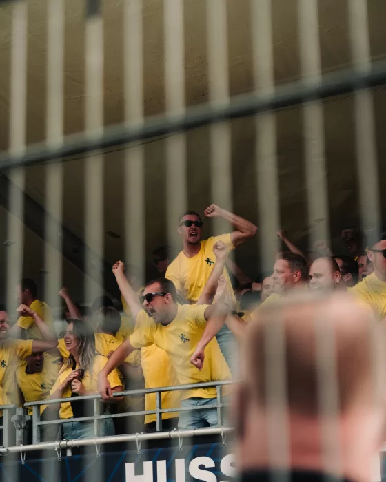 Supporters juichen achter het hek