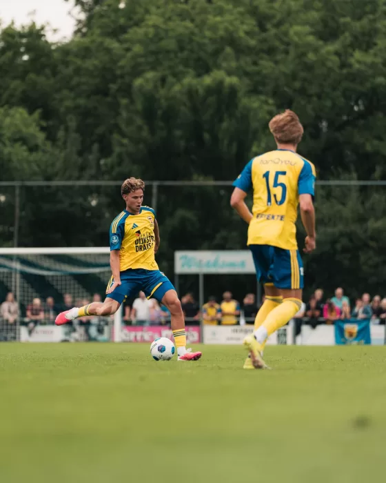 Twee jeugdspelers met de bal op het veld
