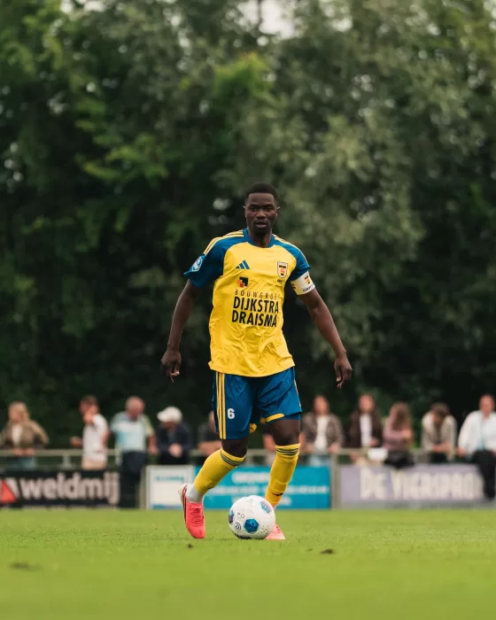 Jeugdspeler in geel aan de bal