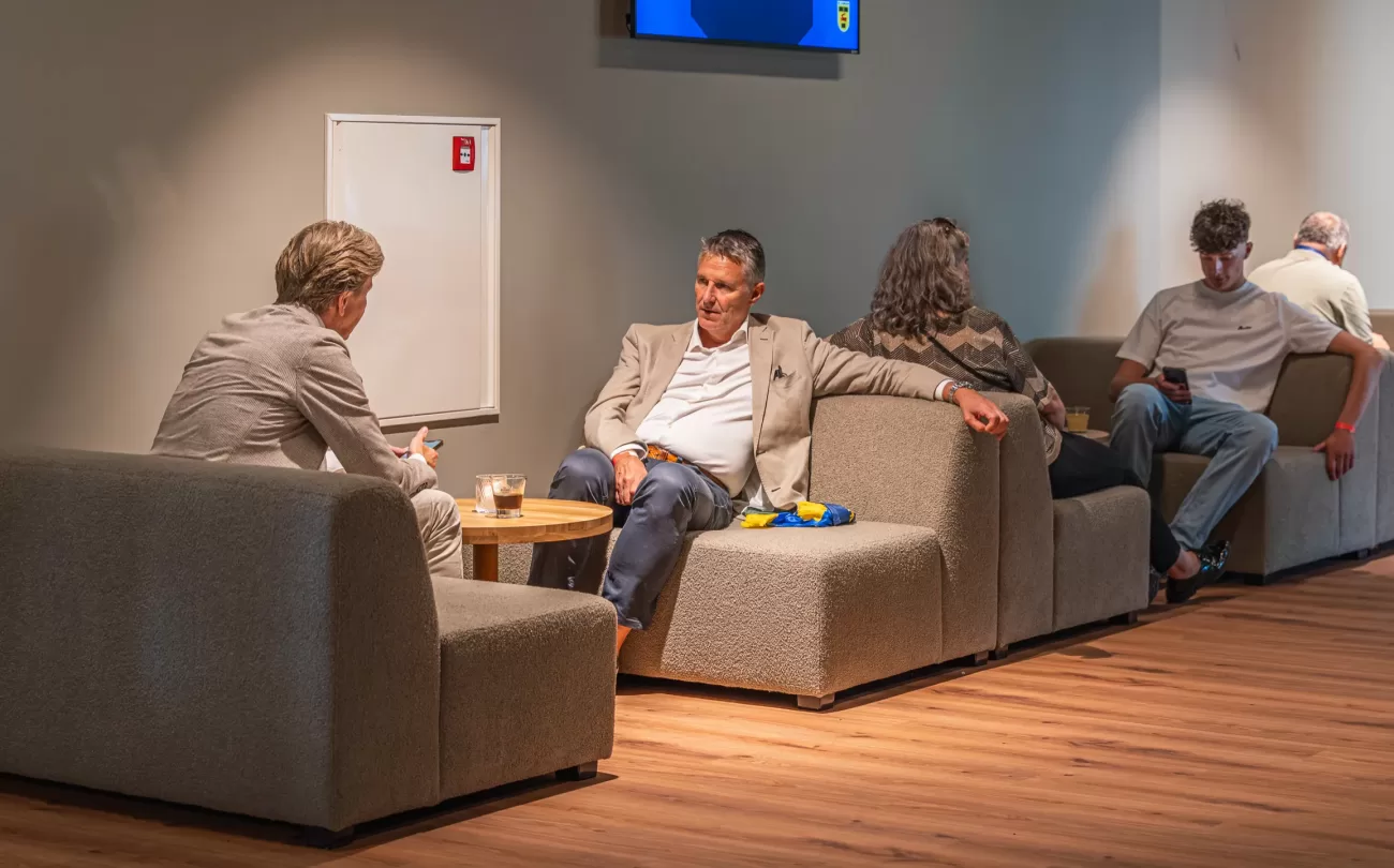 Gasten op de banken in de lounge van de Businessclub