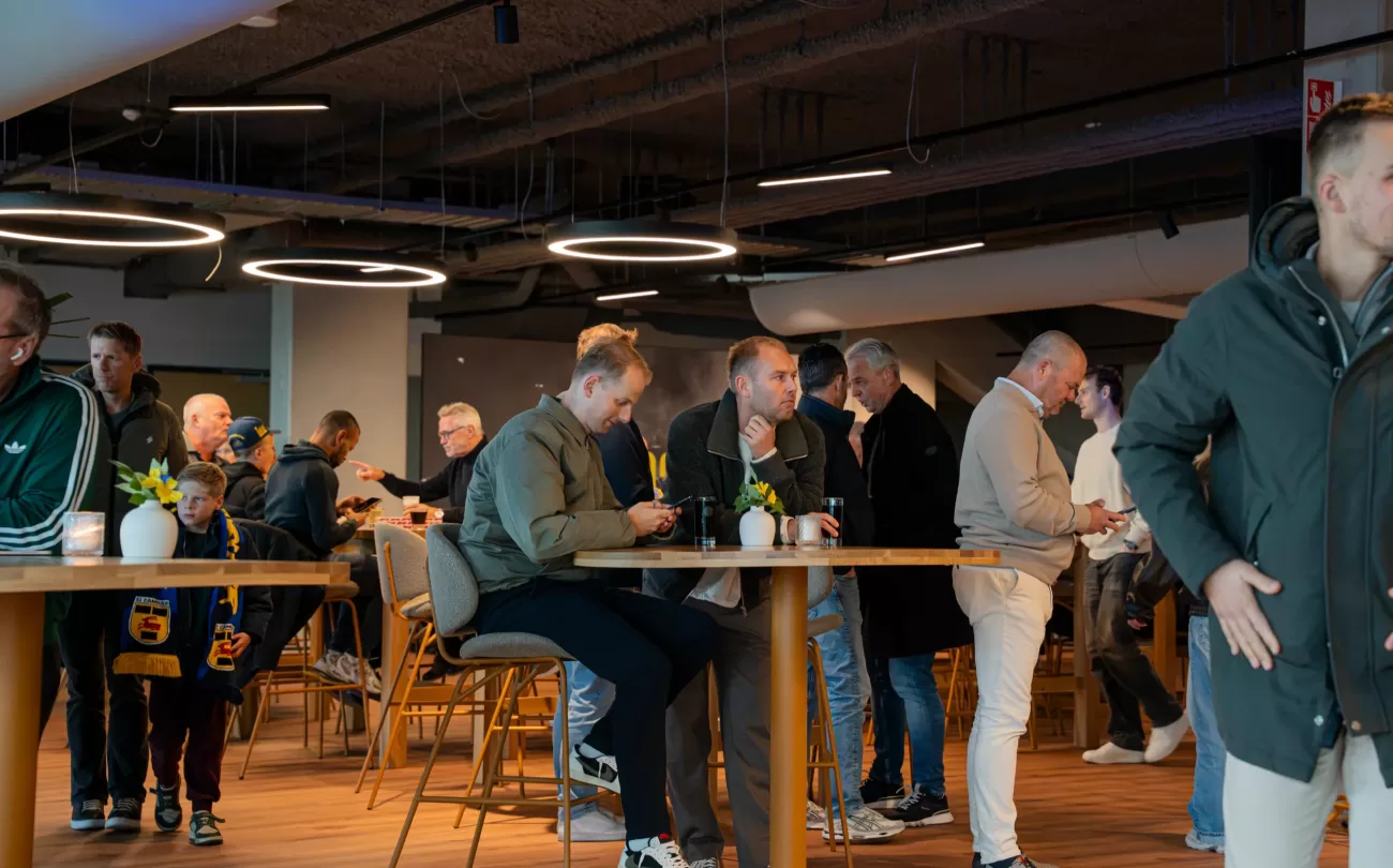Drukte aan de statafels in de businessclub